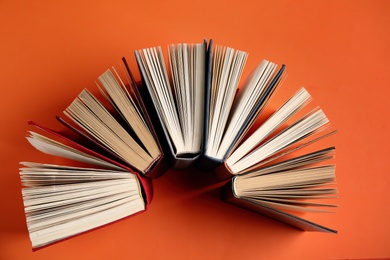 Photo of Hardcover books on orange background, flat lay