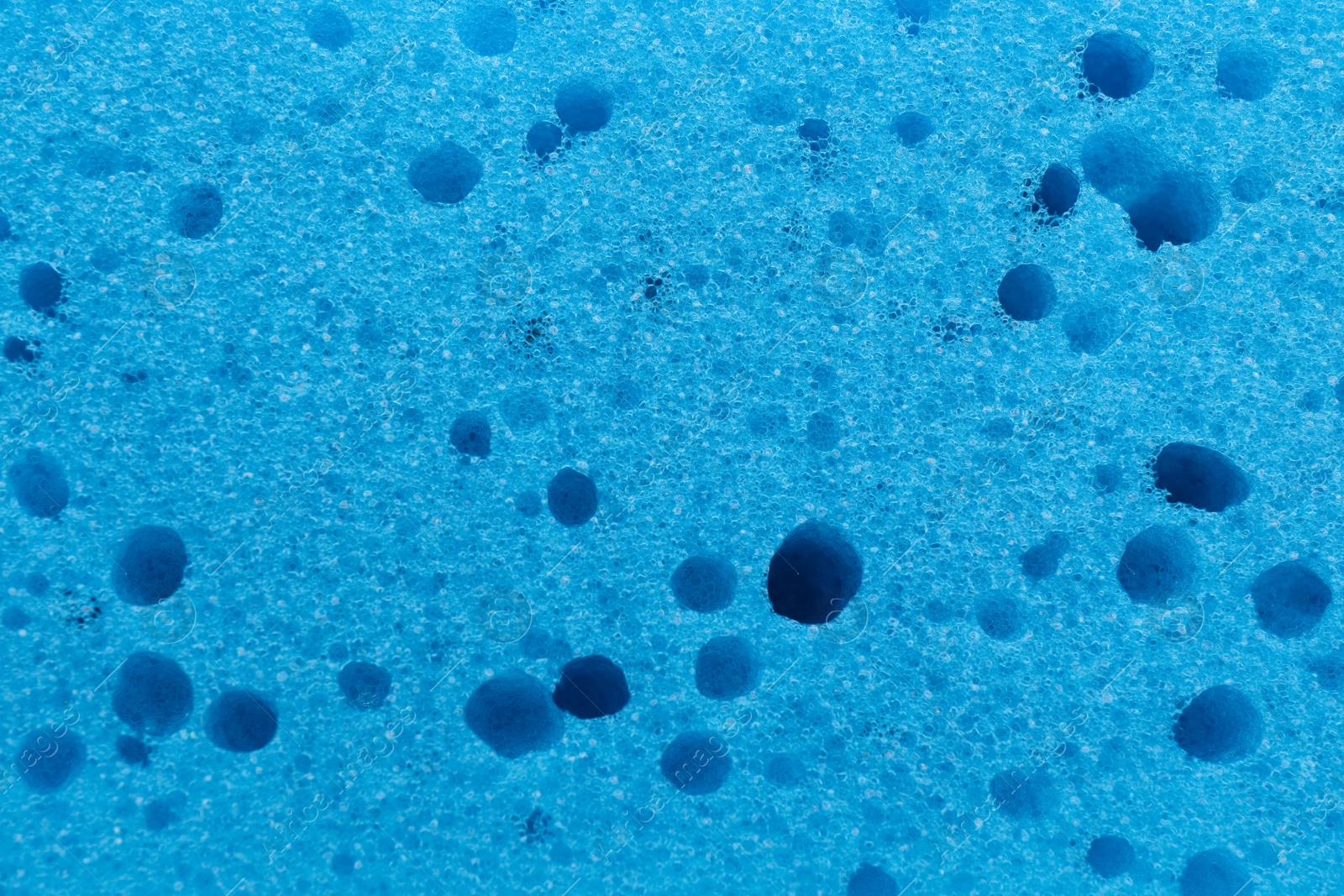 Photo of Light blue cleaning sponge as background, top view