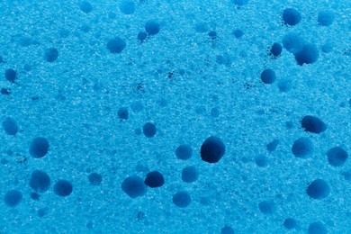 Photo of Light blue cleaning sponge as background, top view