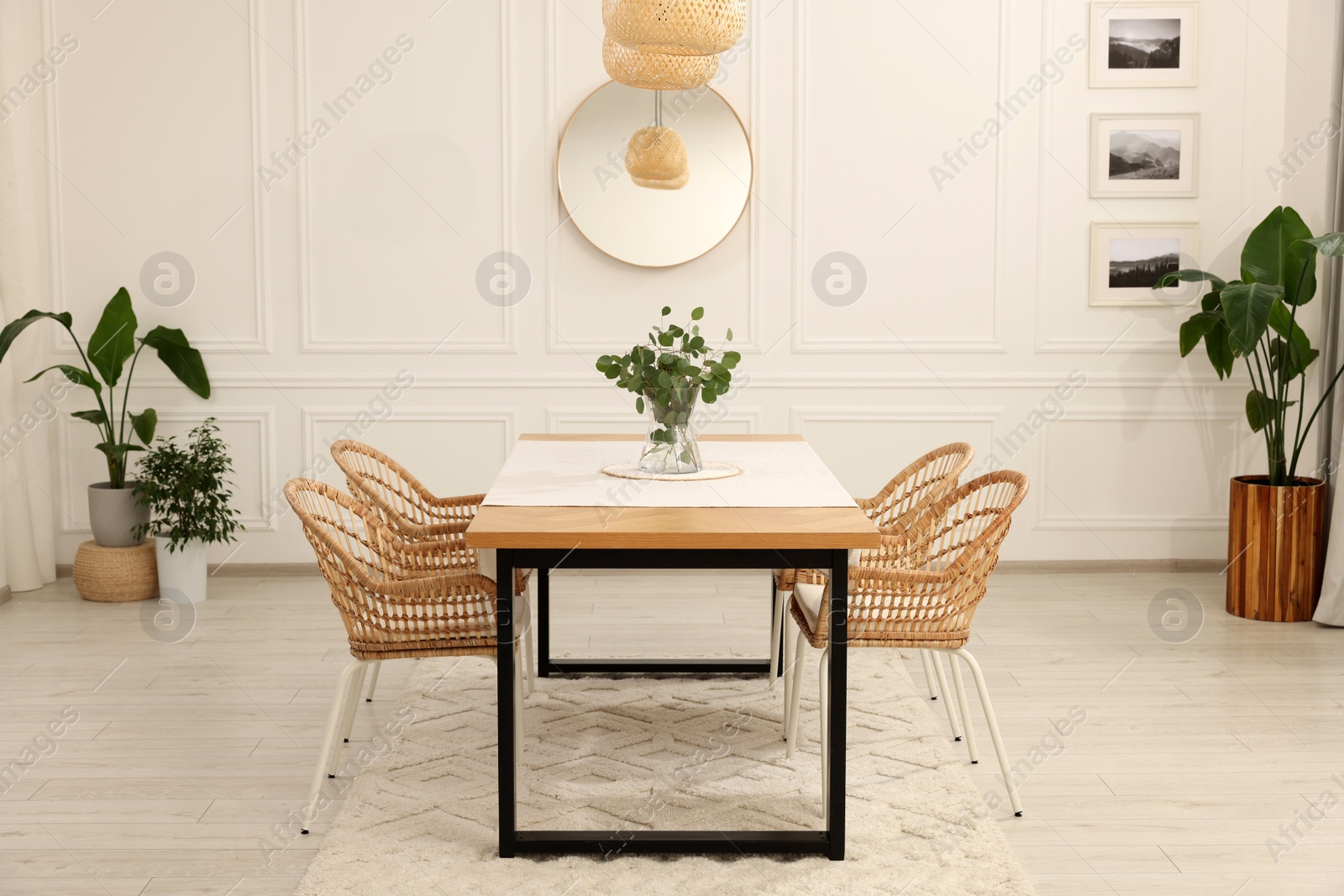 Photo of Stylish dining room with cozy furniture, mirror and plants