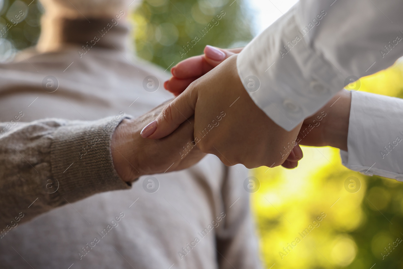 Photo of Trust and support concept. People joining hands outdoors, low angle view