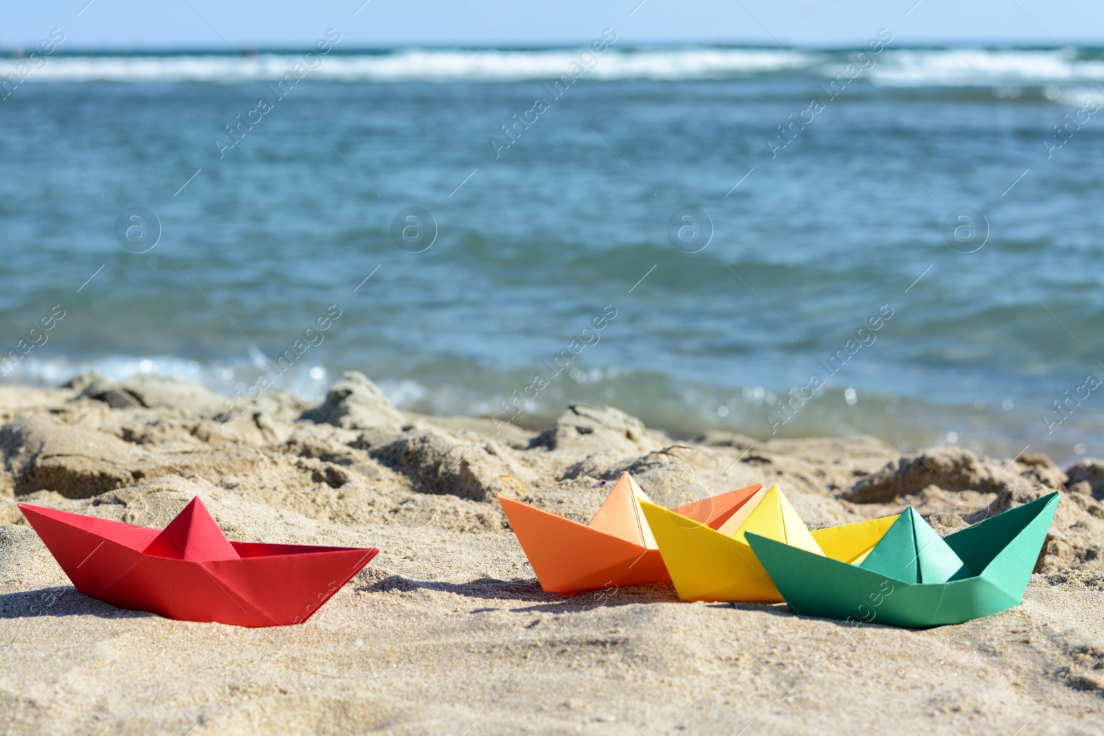 Photo of Many paper boats near sea on sunny day