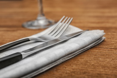Photo of Cutlery and napkin on wooden background, close up view. Table setting
