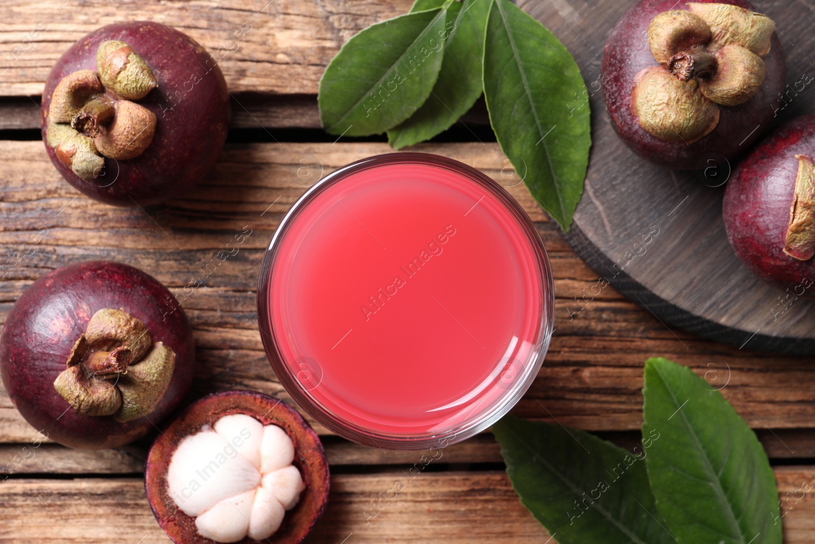 Photo of Delicious fresh mangosteen juice on wooden table, flat lay