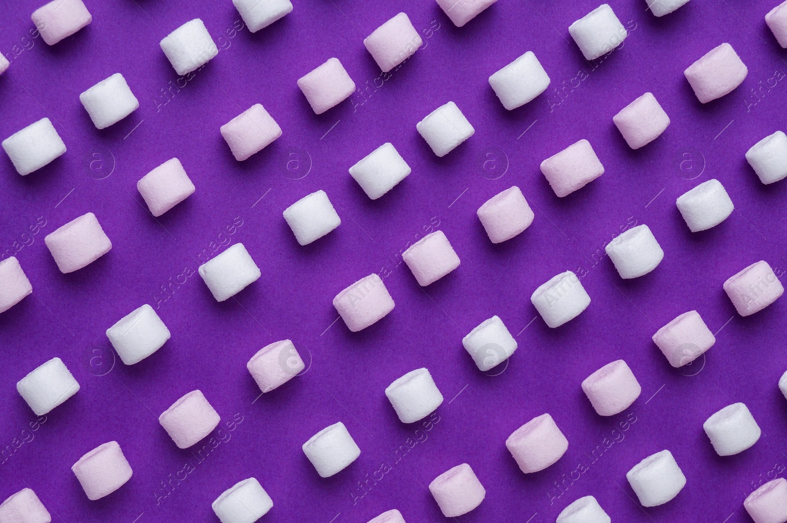 Photo of Delicious marshmallows on purple background, flat lay