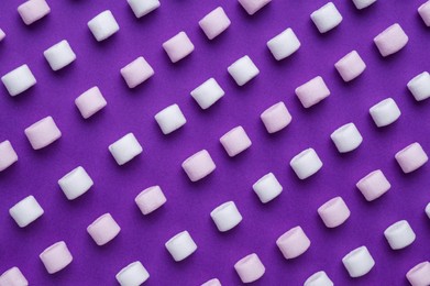 Delicious marshmallows on purple background, flat lay