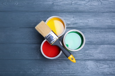 Photo of Flat lay composition with paint cans and brush on wooden background