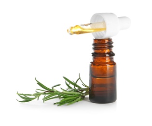 Small bottle with rosemary oil and fresh twig on white background