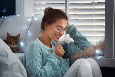 Young woman with hot drink at home. Cozy winter