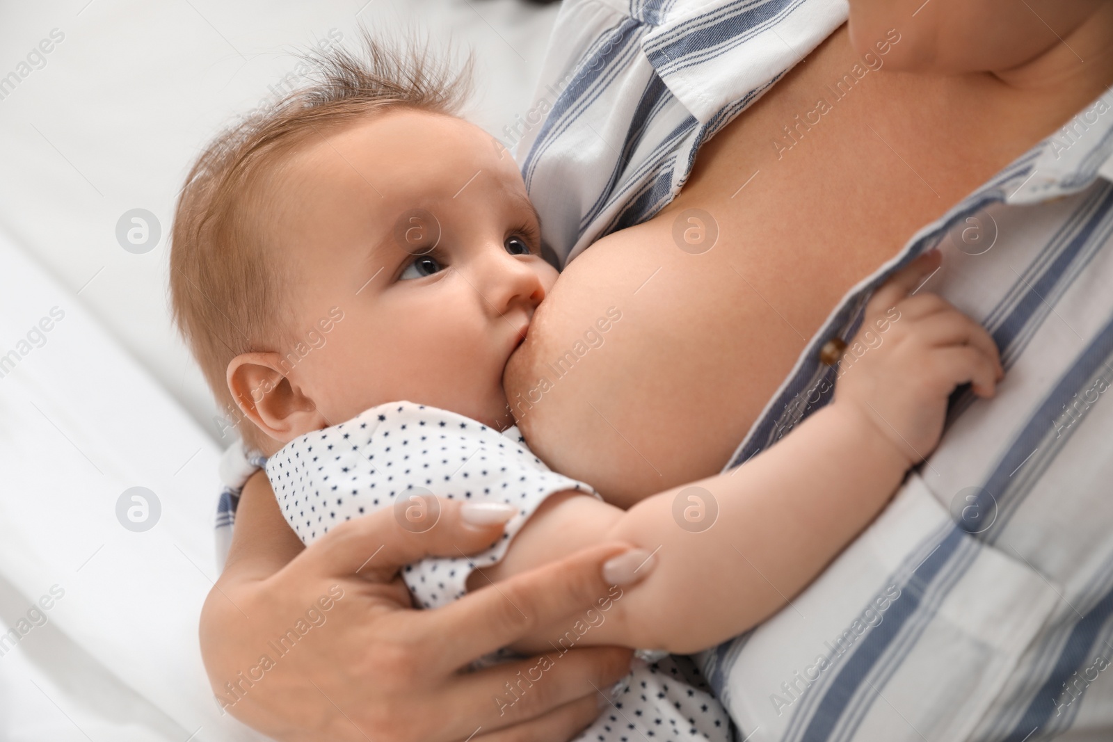 Photo of Woman breastfeeding her little baby at home