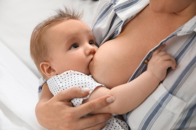 Photo of Woman breastfeeding her little baby at home