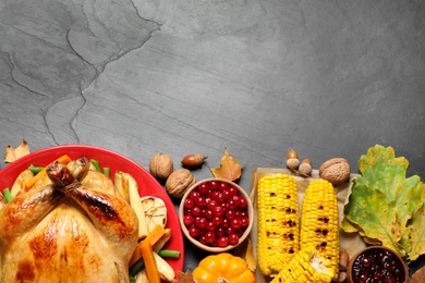Photo of Traditional Thanksgiving day feast with delicious cooked turkey and other seasonal dishes served on black table, flat lay. Space for text