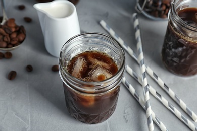 Photo of Jar with cold brew coffee on grey background