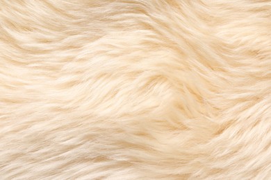 Photo of Texture of beige faux fur as background, top view