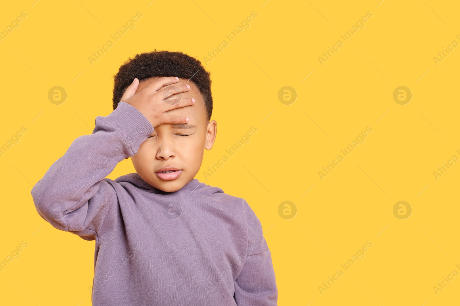 Photo of Emotional African-American boy on yellow background. Space for text