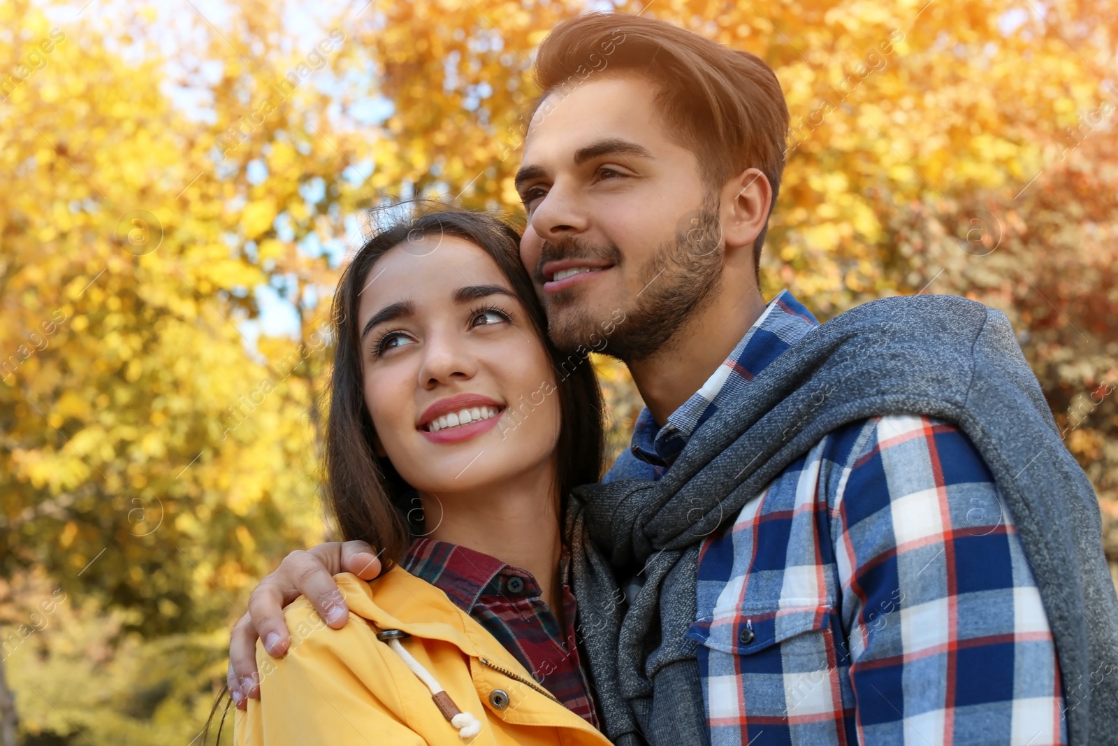 Photo of Young lovely couple spending time together in park. Autumn walk