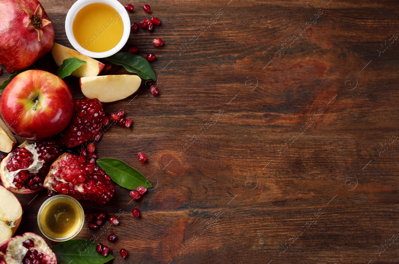 Photo of Flat lay composition with honey and fruits on wooden table, space for text. Rosh Hashanah holiday