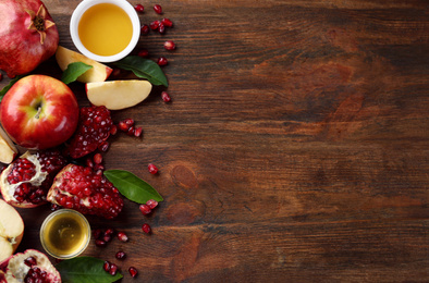 Photo of Flat lay composition with honey and fruits on wooden table, space for text. Rosh Hashanah holiday