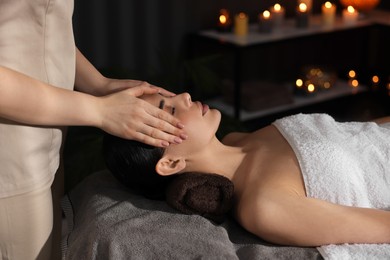 Spa therapy. Beautiful young woman lying on table during massage in salon