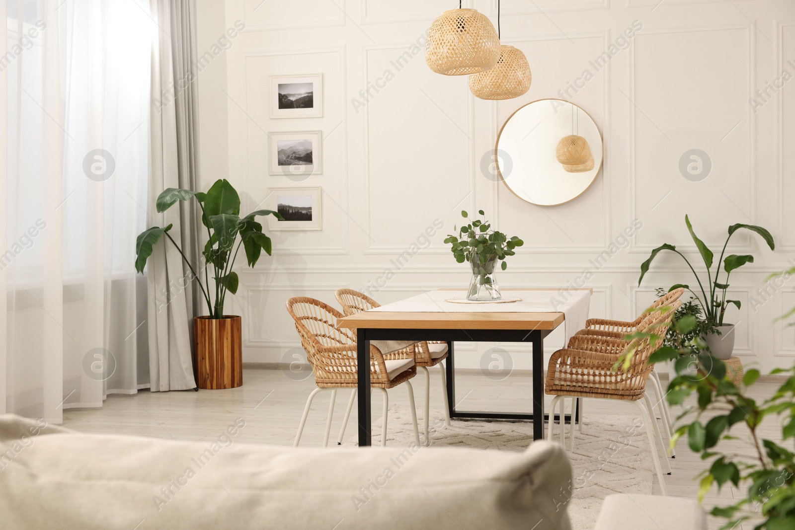 Photo of Stylish dining room with cozy furniture, mirror and plants