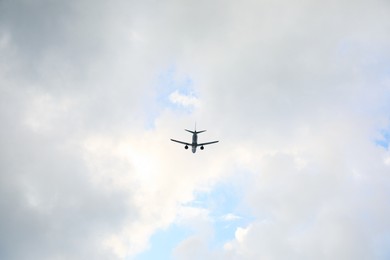 Photo of Modern white airplane flying in cloudy sky, low angle view