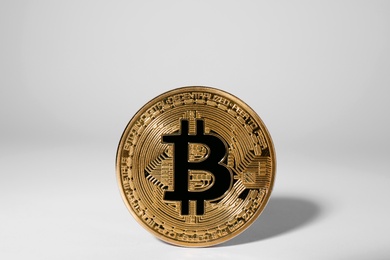 Shiny gold bitcoin on light background. Digital currency
