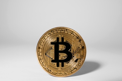 Photo of Shiny gold bitcoin on light background. Digital currency