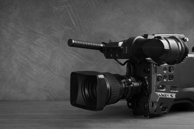 Photo of Video camera on grey wooden table, closeup