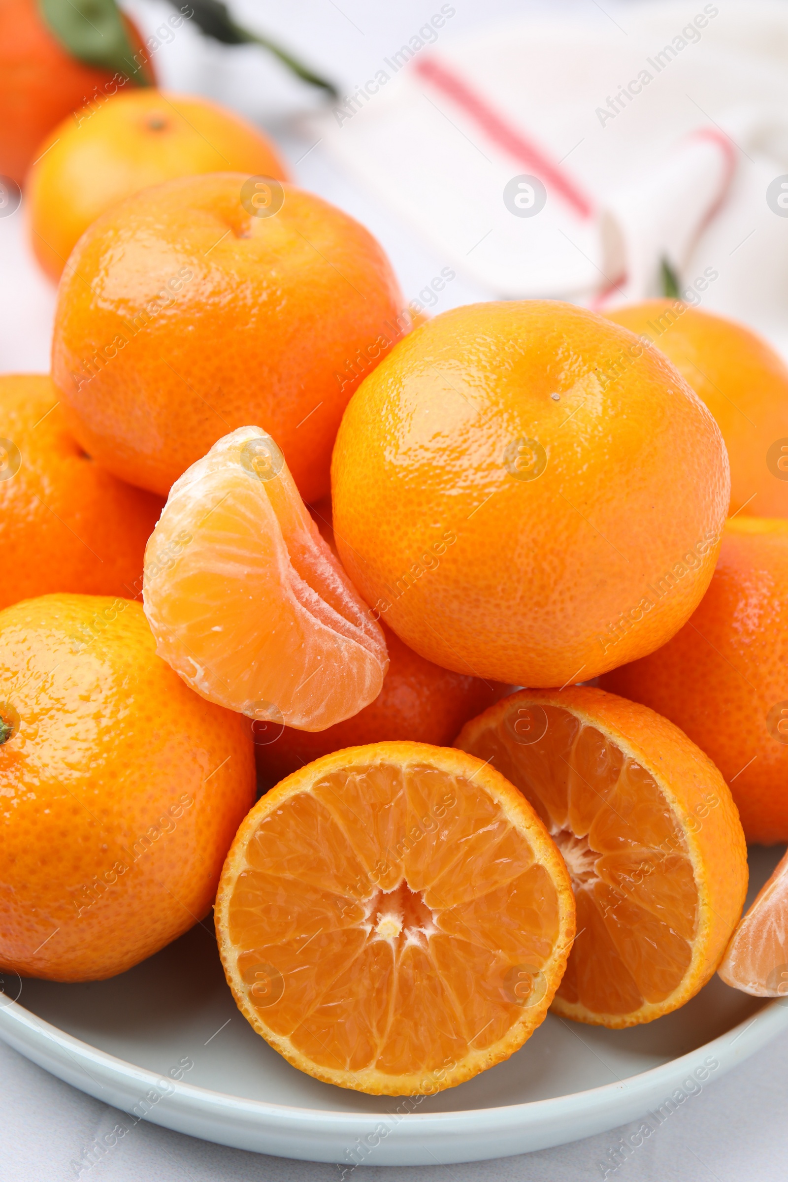 Photo of Plate of fresh juicy tangerines on white table, closeup