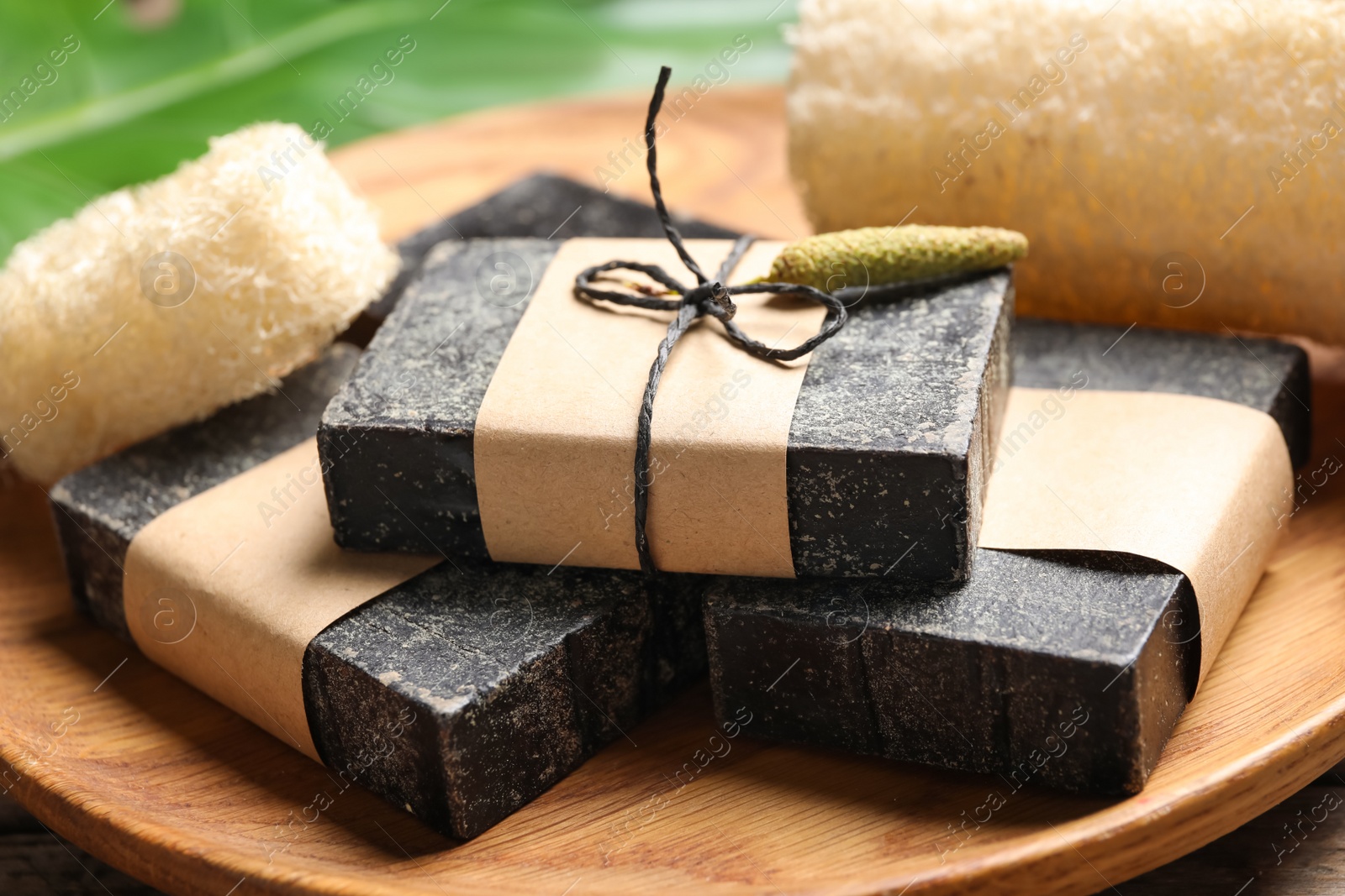 Photo of Natural tar soap on wooden board, closeup