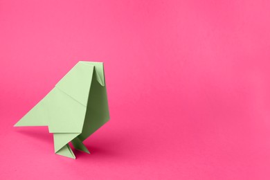 Photo of Paper bird on pink background, space for text. Origami art