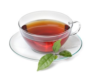 Photo of Glass cup of hot aromatic tea and green leaves on white background