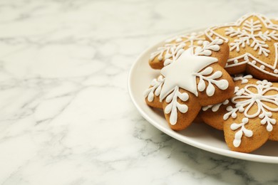 Tasty star shaped Christmas cookies with icing on white marble table, closeup. Space for text