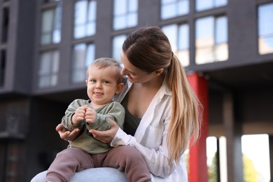 Happy nanny with cute little boy outdoors