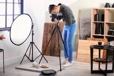 Photo of Young man taking picture of food in photo studio