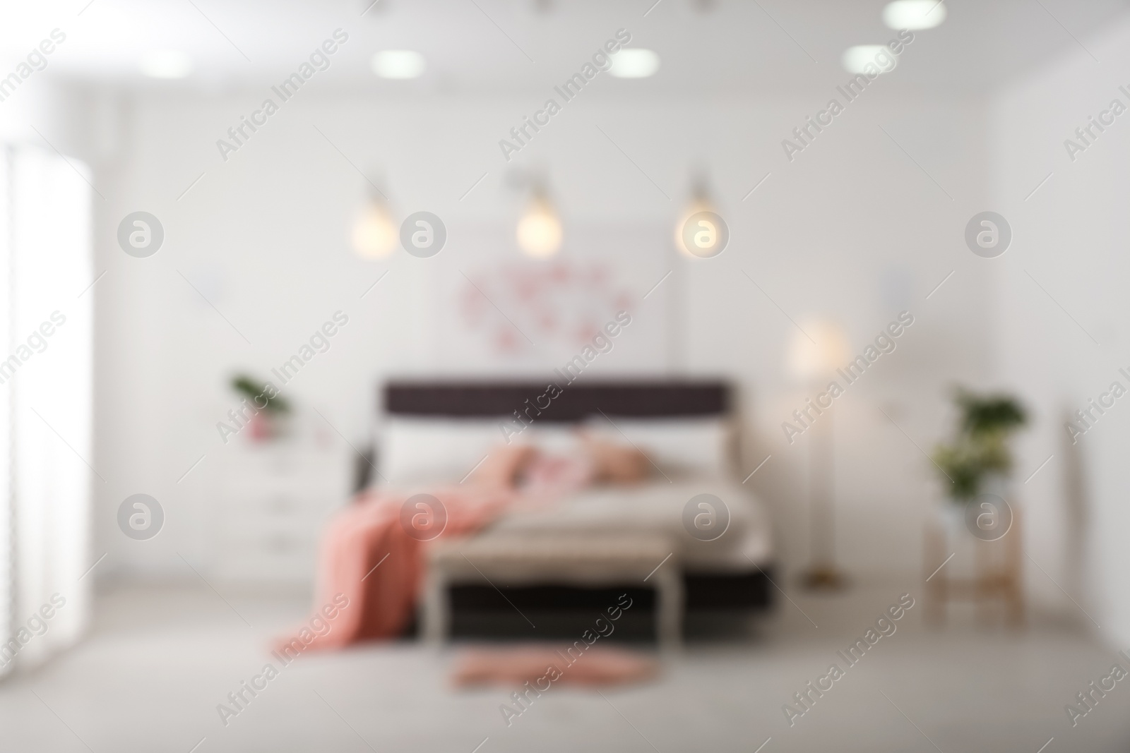 Photo of Blurred view of stylish room interior with comfortable bed