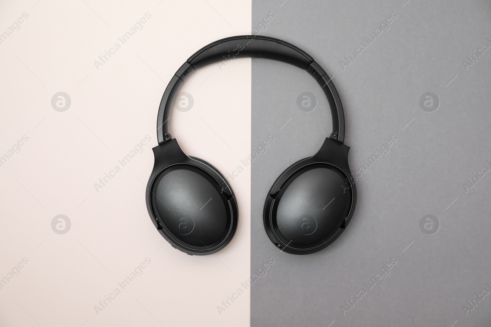 Photo of Modern wireless headphones on color background, top view