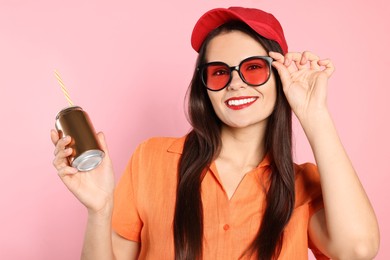 Photo of Beautiful young woman holding tin can with beverage on pink background