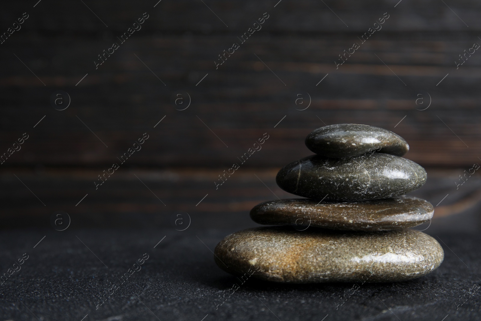 Photo of Stack of zen stones on table against blurred background. Space for text