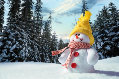 Image of Cute small decorative snowman outdoors on sunny day, space for text