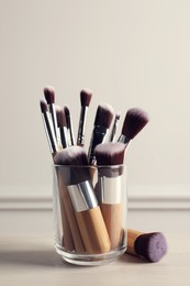 Photo of Setprofessional makeup brushes on table against white background