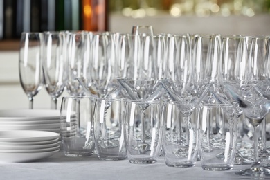 Photo of Set of empty glasses and dishware on table indoors