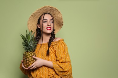 Young woman with fresh pineapple on olive background, space for text. Exotic fruit