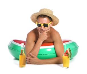 Photo of Shirtless man with inflatable ring,  cocktail and bottle of drink on white background