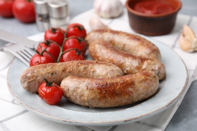 Photo of Plate with tasty homemade sausages and tomatoes on table, closeup