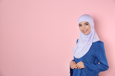 Photo of Portrait of young Muslim woman in hijab against color background. Space for text