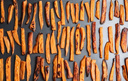 Baked sweet potato slices on grey background, flat lay