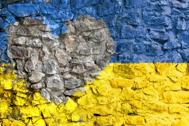 Image of National flag of Ukraine with unpainted heart on old stone wall