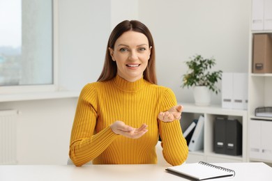 Photo of Woman having video chat at table in office, view from web camera