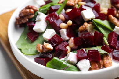 Delicious beet salad served on wooden board, closeup